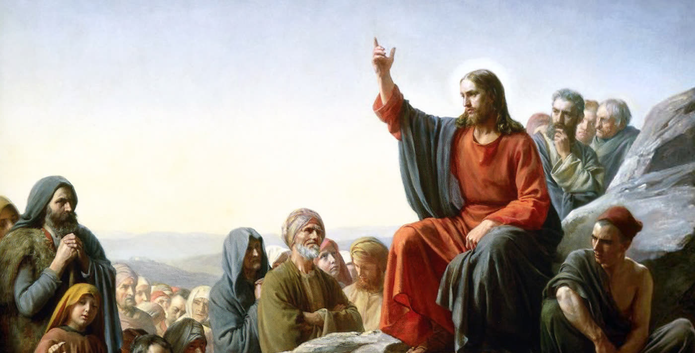 Carl Bloch&rsquo;s painting of the Sermon on the Mount: Christ seated on a rock with one hand raised, speaking to a seated crowd.