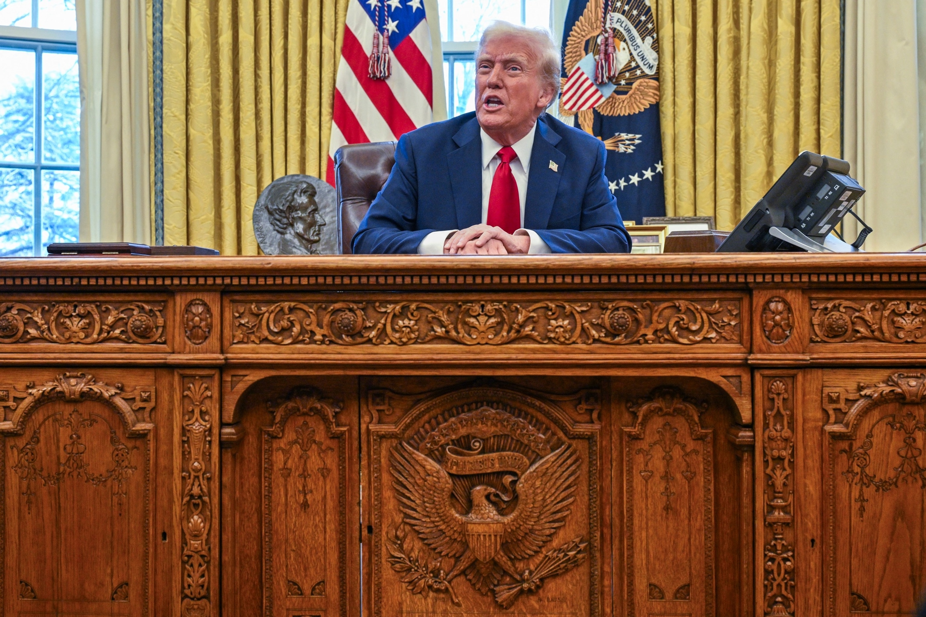 President Trump seated at the Resolute Desk in the Oval Office